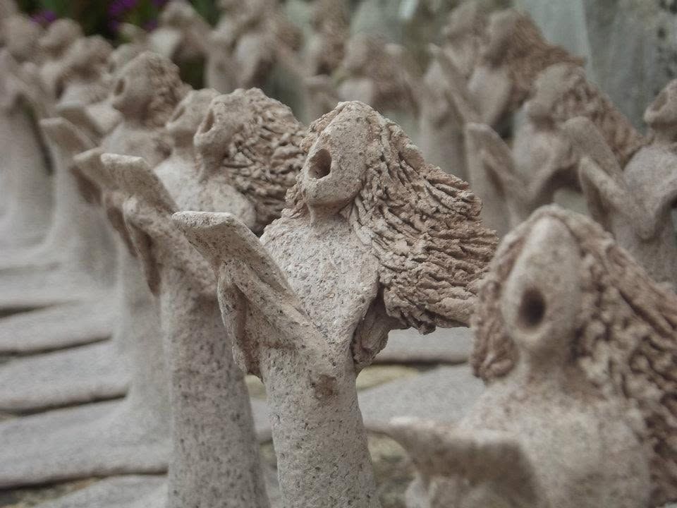 Rows of tall, rough clay figures with wings and long hair