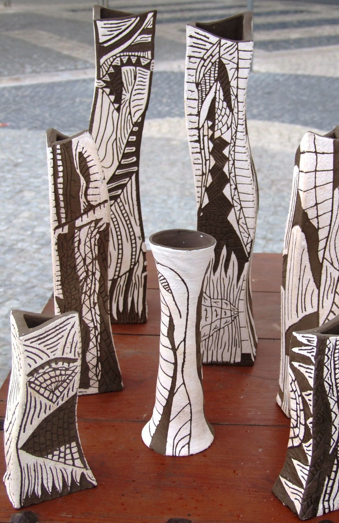 Tall, angular vessels with bold black and white scratched drawings