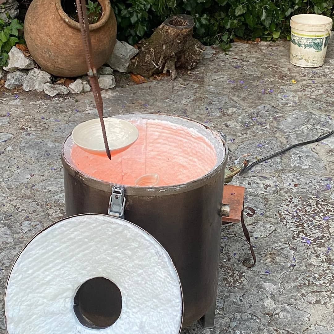 Small raku kiln opened in the garden, the pieces inside glowing orange